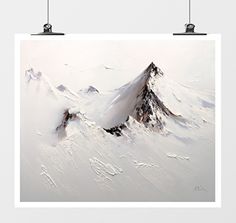 a white poster hanging on a wall next to two black and white pictures with mountains in the background