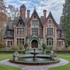 an old house with a fountain in front of it and lots of windows on the side