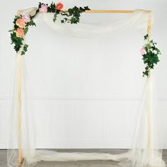 a wedding arch decorated with flowers and greenery