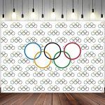 an olympic poster hanging on the wall in front of a wooden floor with lights and chandelier