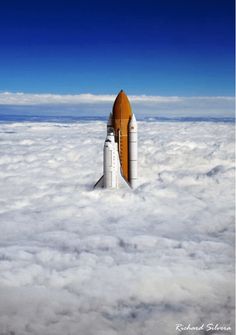 a space shuttle is flying above the clouds