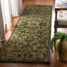 a large green rug in the middle of a living room with a chair and potted plant