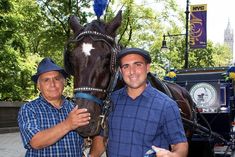 two men are standing next to a horse