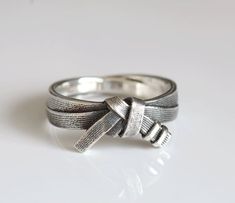 a silver ring with a bow on it