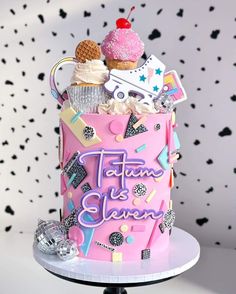 a pink birthday cake with an ice cream sundae on top