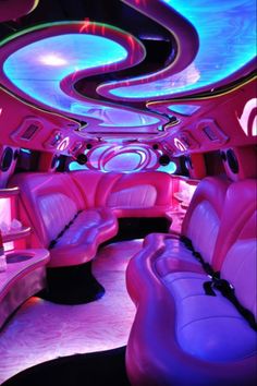 the inside of a limo with purple and blue lights on it's ceiling, seats are upholstered in leather