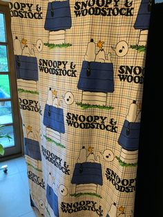 a shower curtain with snoopy and woocky on it in front of a window