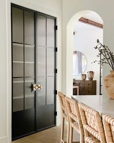 a dining room table and chairs in front of a black door