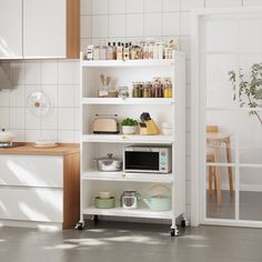 a kitchen with white walls and shelves filled with dishes, appliances and utensils