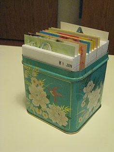 there is a blue tin with flowers on it and many books in the bins