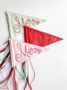 three pennants with the words merry new year on them and ribbons attached to them