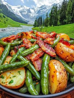 green beans, potatoes and bacon on a plate in front of a mountain lake with snow capped mountains