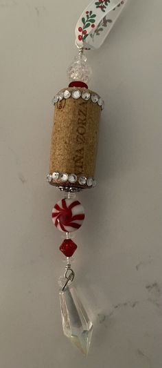 a wine bottle hanging from the side of a cork and glass bead bell ornament