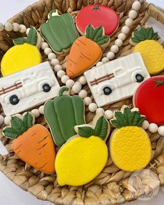 decorated cookies in the shape of fruits and vegetables on a wicker basket with beads