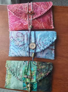 three different purses sitting on top of a wooden table