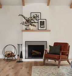 a living room filled with furniture and a fire place in front of a white wall