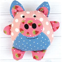 a pink pig with polka dots and strawberries on it's face, sitting in front of a white background