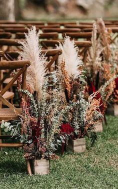 rows of wooden chairs with flowers and greenery on them