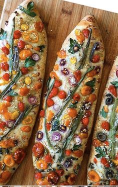 three different types of bread with tomatoes, onions and other toppings on them sitting on a cutting board