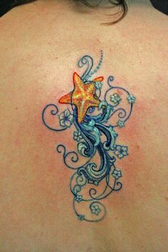 a woman's back with a starfish and swirls tattoo design on it