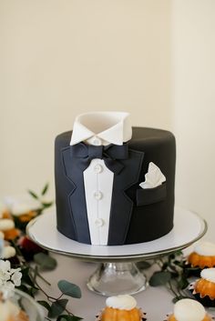 there is a black and white cake with a bow tie on it