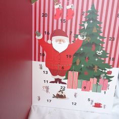 a christmas card with santa standing in front of a tree and numbers on the side