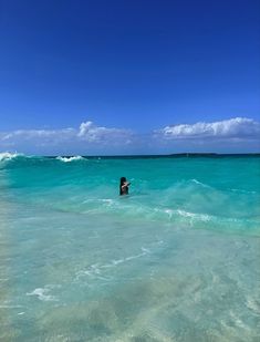 a person standing in the ocean on top of a surfboard