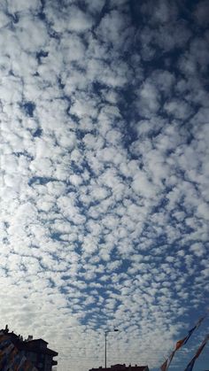 the sky is full of clouds and some buildings