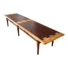 a wooden table sitting on top of a white floor next to a pair of legs