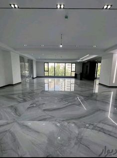 an empty room with marble floors and large windows