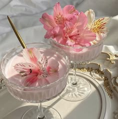 two dessert dishes with pink flowers in them on a white tray and gold trimmings