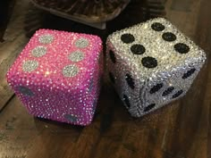 two shiny dices sitting on top of a wooden table