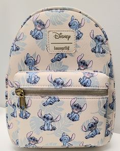 The photos for this listing are stock photos. This means that the print design on the bag shown in the pictures is not necessarily the exact bag that you will receive. It will have all the same characters. They just might be featured in different locations on the bag. This Loungefly Disney Lilo & Stitch Tropical Leaves Mini Backpack is perfect for any Disney fan! With a cute Stitch character design and tropical leaves accents, this backpack is a must-have accessory. The white handle/strap and brass hardware color create a stylish contrast with the multicolor exterior material of polyurethane. It's the perfect size for carrying your essentials, and the backpack style makes it easy and comfortable to wear for any occasion. Add this to your collection today! Approximate Size: 8 x 5 x 11 Inche Stitch Character Design, Loungefly Disney Backpack, Lilo And Stitch Toys, Disney Backpack, Lilo And Stitch Merchandise, ليلو وستيتش, Lilo And Stitch Quotes, Stitch Backpack, Stitch Toy