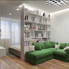 a green couch sitting in front of a book shelf