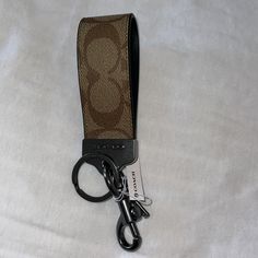 a brown and black lanyard with a keychain on it's side