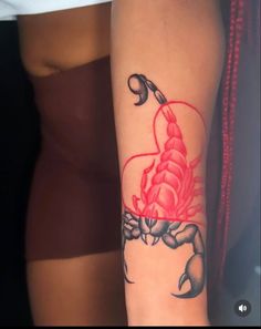 a woman's arm with a scorpion tattoo on it and a heart in the middle