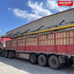 a large truck with many crates on the back is parked in front of a building