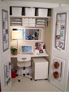 an open closet with a computer on the desk