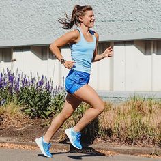 a woman running down the street in blue shorts