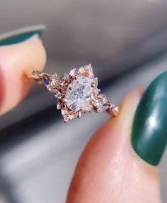 a woman's hand holding an engagement ring with diamonds on the top and bottom