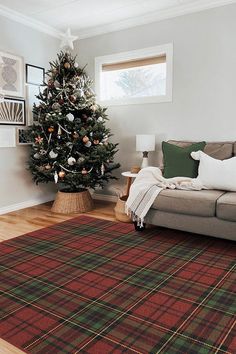 a living room with a christmas tree in the corner and plaid rug on the floor