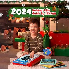 a young boy sitting on the floor in front of christmas decorations and presents, holding a holiday gift guide by tektun