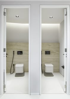 two white toilets sitting next to each other in a bathroom