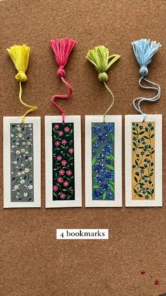 four small cards with tassels on top of each one in different colors and designs