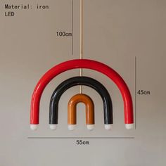 a red, black and white light hanging from a ceiling fixture with measurements for the length