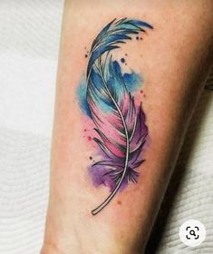 a watercolor feather tattoo on the ankle