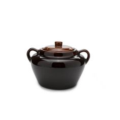 a black pot with a brown lid on a white background, it is also used as a container for food