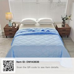 a bed with blue sheets and pillows in a bedroom next to a lamp on a table