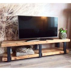 a flat screen tv sitting on top of a wooden stand