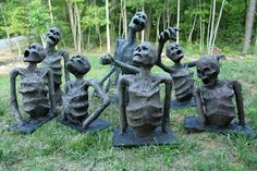 a group of sculptures sitting on top of a lush green field